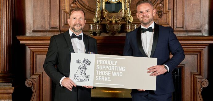 Two men holding an Armed Forces Covenant plaquard