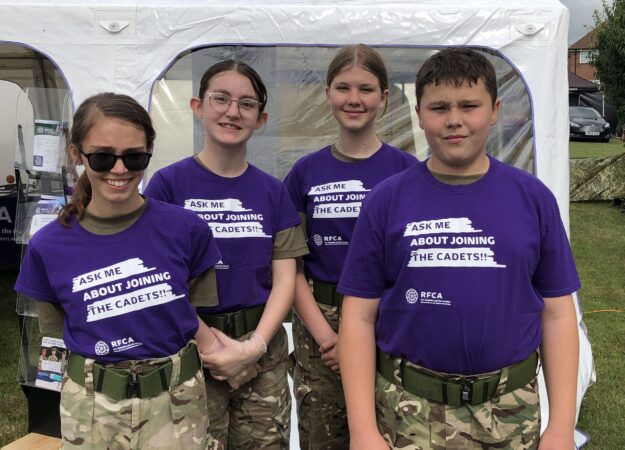four smiling cadets standing in a row