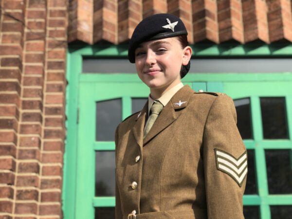 Young woman in uniform looking down at the camera and smiling