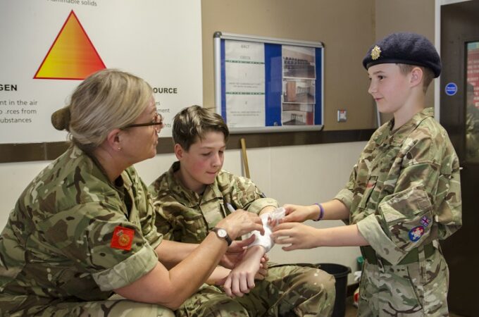 Adult volunteer teaching first aid to cadt