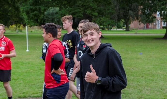 Smiling cadet playing football on camp