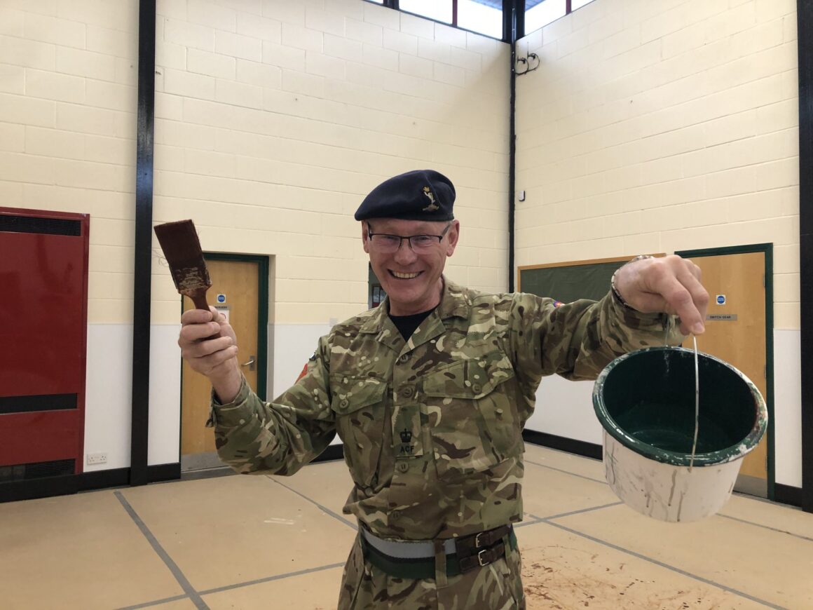 Cadet volunteer with paint brush and can