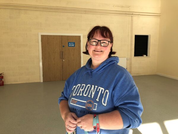 Smiling adult volunteer in empty drill hall
