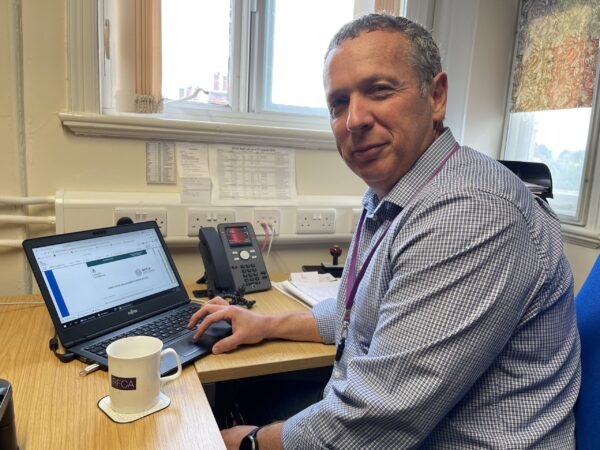 Man in front of computer screen with RFCA newsletter written on it