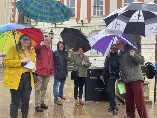 Group carrying umbrellas in York city centre
