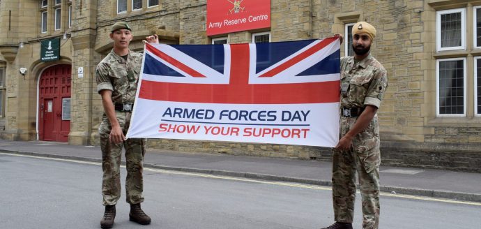 Two reserves from 4YORKS carry the Armed Forces Week flag